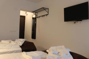 Zimmer mit einem TV und einem Stapel Handtücher in der Unterkunft Hotel Parang in Băile Olăneşti