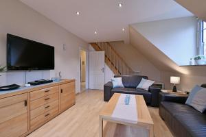 a living room with a couch and a flat screen tv at Appartement-Blume-PCH-16B in Scharbeutz