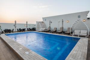 a pool at a hotel with chairs and tables at Landmark Hotels & Suites - Formerly Qamar Hotel in Jeddah