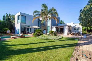 eine Villa mit einer Palme vor einem Hof in der Unterkunft CAN COOL in Ibiza-Stadt
