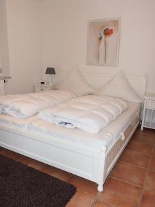 un letto bianco con cuscini sopra di Hanseaten-Residenz-FIS-501 a Scharbeutz