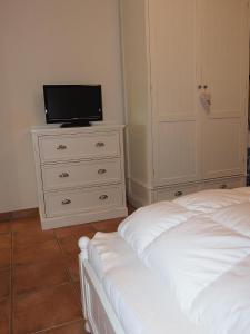 シャルボイツにあるHanseaten-Residenz-FIS-501のベッドルーム(ベッド1台、ドレッサー内のテレビ付)