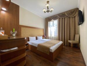 a bedroom with a bed and a desk and a window at Boomerang Business Hotel in Odesa
