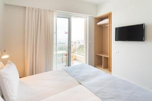 - une chambre avec un lit, une télévision et un balcon dans l'établissement Ibiscos Garden Hotel, à Réthymnon