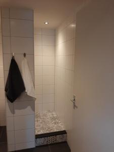 a bathroom with a shower with a bench in it at Appartementen Hoek 1 in Baflo