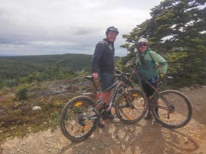 two people standing on a hill with their bikes at Casa Bike in Punta Arenas