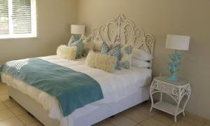 a bedroom with a white bed with blue and white pillows at 8 Oyster in Durban +31 photos