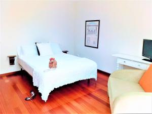 - une chambre avec un lit avec un chien assis dans l'établissement LARGE Apartment with large and sunny Terrace - Garden & Outdoor Gym , ALICANTE CENTER, à Alicante