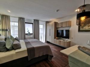 a bedroom with a bed and a flat screen tv at RhePi-Apartment in Essen