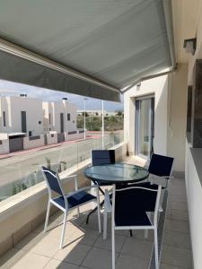 a balcony with a glass table and chairs on it at Apartamento con solarium Villa Amalia in Torrevieja