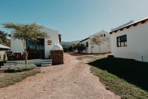 a dirt road in front of a white house at Sionshoop in Van Wyksdorp