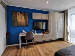 a bedroom with a desk and a blue wall at RhePi-Apartment in Essen