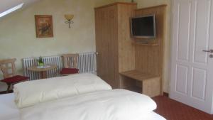 1 dormitorio con 1 cama y TV en la pared en Weinhaus Paradies, en Neustadt an der Weinstraße