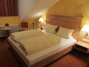 a bedroom with a large bed with white sheets and pillows at Weinhaus Paradies in Neustadt an der Weinstraße