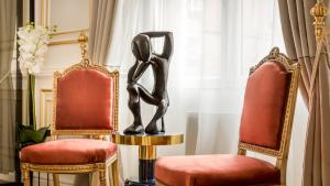 a room with two chairs and a statue on a table at Luxury 6 Bedroom 5 bathroom Palace Apartment - Louvre View in Paris