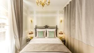 a bedroom with a large bed with a chandelier at Luxury 6 Bedroom 5 bathroom Palace Apartment - Louvre View in Paris