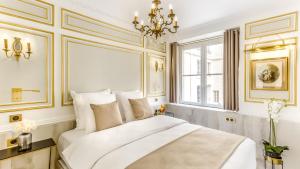 um quarto com uma grande cama branca e uma janela em Luxury 6 Bedroom 5 bathroom Palace Apartment - Louvre View em Paris