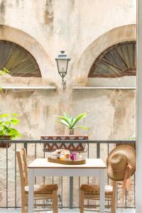 Cassaro261 B&B في باليرمو: طاولة وكراسي على شرفة مع جدار