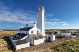 a lighthouse in the middle of a field at Finest Retreats - Lighthouse Cottage in Rampside