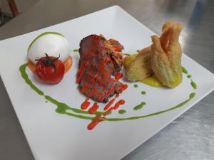 a plate of food with meat and a tomato at Luna Convento Copanello B&B in Stalettì