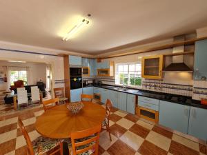 uma cozinha com uma mesa de madeira e uma sala de jantar em Villa Duartes em Altura