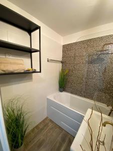 baño con bañera y planta en Loft Apartman X. ker., en Budapest