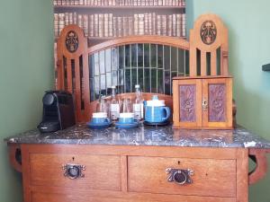 Afallon Townhouse Gwynedd Room في دولغيلوو: خزانة خشبية مع أعلى منضدة مع طعام عليها