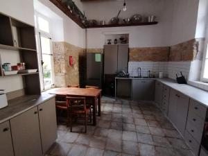 a kitchen with a wooden table and a tableasteryasteryasteryasteryasteryasteryastery at Le Mat Hostel in Larnaca