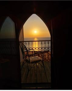 a view of the sunset from a balcony with a chair at Luna Convento Copanello B&B in Stalettì
