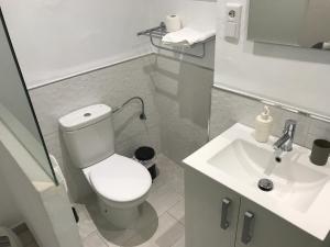 a white bathroom with a toilet and a sink at Tarifa Bed and Center in Tarifa