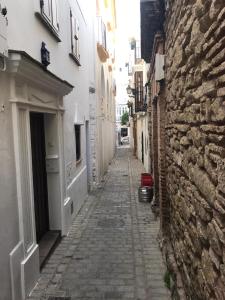 an alley with a stone wall and a cobblestone street at Tarifa Bed and Center in Tarifa