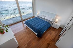 een slaapkamer met een bed en een groot raam bij Villa Luthien in Brenzone sul Garda