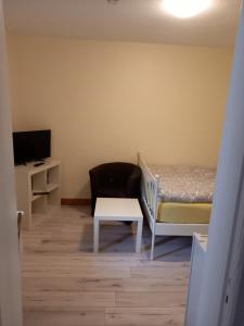 1 dormitorio con 1 cama, 1 silla y TV en Monteurzimmer Lützow, en Lübeck