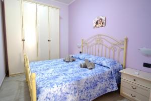 a bedroom with a bed with a blue comforter at La rosa dei venti, apartment 1 in Porto Empedocle