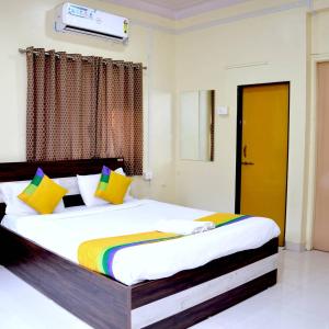 a bedroom with a large bed with colorful pillows at Hotel Bestow Inn Koregaon Park Pune -Near Osho Ashram in Pune