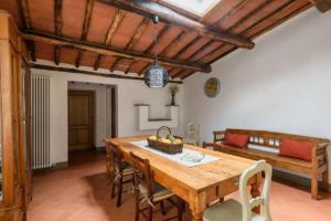 uma sala de jantar com uma mesa de madeira e um sofá em Agriturismo le Bartaline em Pieve di Panzano