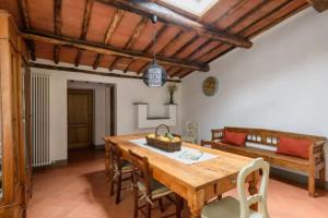 een eetkamer met een houten tafel en een bank bij Agriturismo le Bartaline in Pieve di Panzano