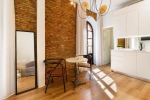 una sala da pranzo con tavolo e muro di mattoni di Apartamentos Casapalma Centro Histórico a Málaga