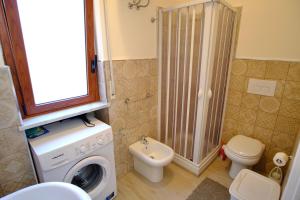 a bathroom with a washing machine and a toilet at La rosa dei venti, apartment 1 in Porto Empedocle