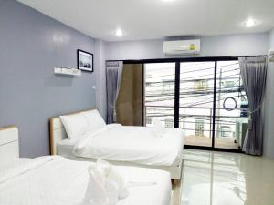 a hotel room with two beds and a window at Khoksametchun Hostel Plus in Hat Yai