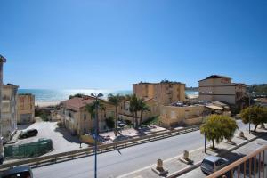 a city street with buildings and the ocean in the background at La rosa dei venti, apartment 1 in Porto Empedocle