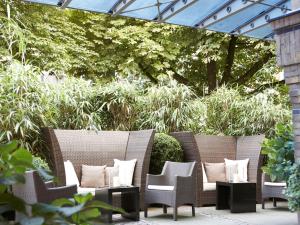 a patio with wicker chairs and pillows at Boston Hotel HH in Hamburg