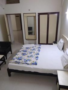 - une chambre avec un grand lit blanc et une chaise dans l'établissement Vamoose Park Palace, à Bharatpur