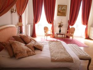 Chateau de la Foltière في Le Châtellier: غرفة نوم بسرير كبير مع ستائر حمراء