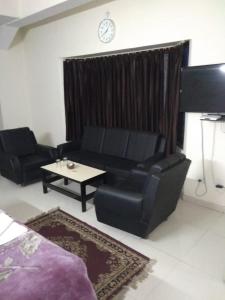 uma sala de estar com um sofá preto e uma mesa em Vamoose Park Palace em Bharatpur