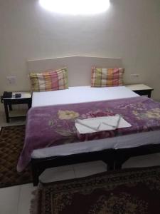 um quarto com uma cama grande e um cobertor roxo em Vamoose Park Palace em Bharatpur