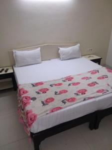 - un grand lit avec une couverture de fleurs dans l'établissement Vamoose Park Palace, à Bharatpur