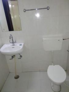 La salle de bains est pourvue de toilettes blanches et d'un lavabo. dans l'établissement Vamoose Park Palace, à Bharatpur