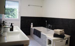 a bathroom with a bath tub and a sink at Haus Melchaazopf in Giswil