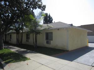 a white house with a palm tree in front of it at Tropico Motel in Glendale